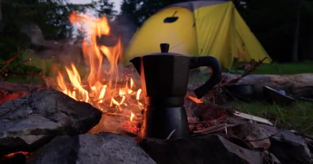 Koffiepot bij het vuur en de tent in het bosgebied — Stockvideo
