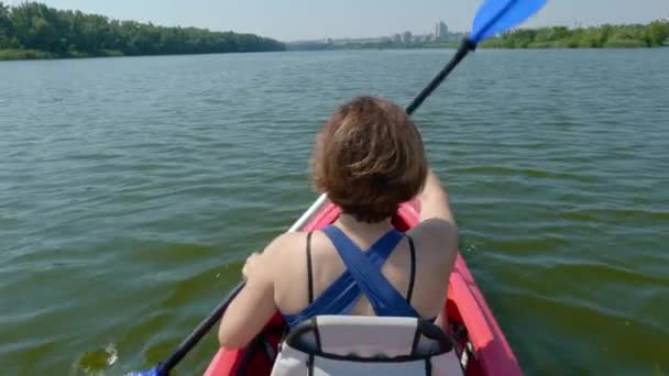 Woman swims on a kayak on a calm river — Vídeos de Stock