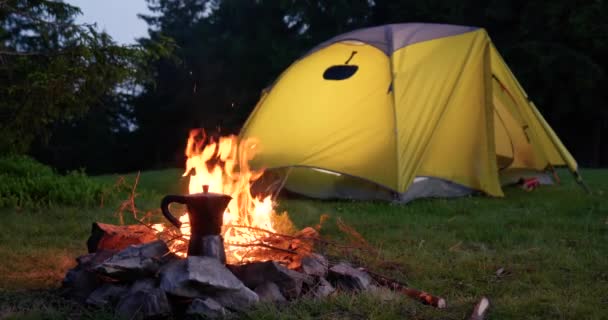 Кофейник у костра и палатка на лесной поляне — стоковое видео