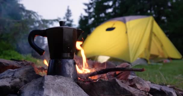 Kaffeekanne am Feuer und Zelt auf der Waldlichtung — Stockvideo