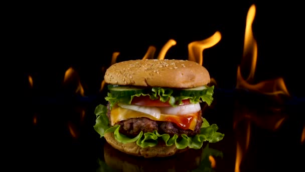 Ateşin arka planında lezzetli bir burger. — Stok video