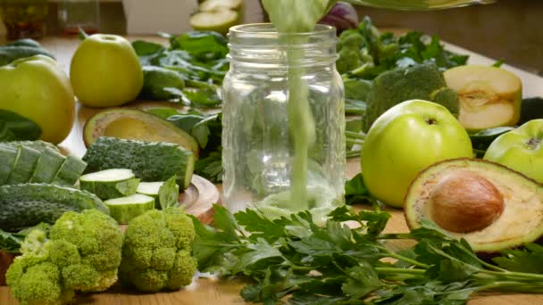 Pouring Organic Freshly Squeezed Green Vegetable and Fruit smoothie Into the jar — Stock video
