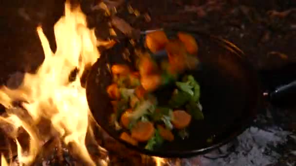 Freír el brócoli y las zanahorias en una sartén sobre un fuego — Vídeo de stock