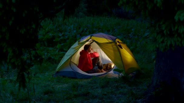 Человек в палатке в ночном лесу — стоковое видео