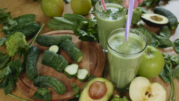 Vegetales verdes recién exprimidos orgánicos y batido de frutas en el vaso — Vídeo de stock