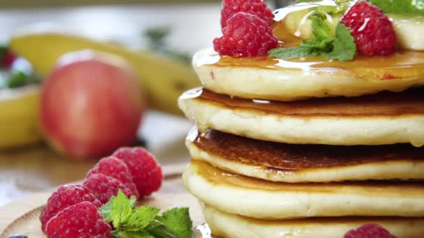 팬케이크쌓아 놓은 곳에서 꿀을 퍼 먹으면서. 맛있는 아침 식사 — 비디오
