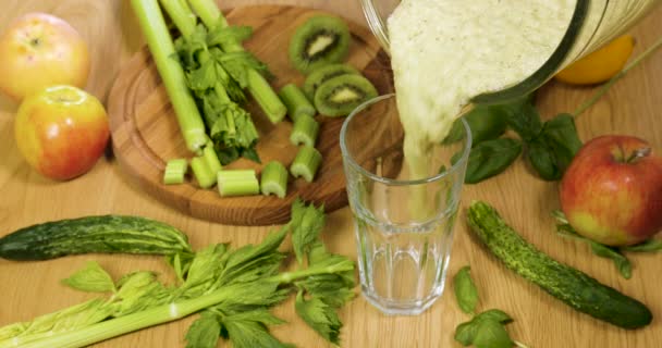 Verter verduras verdes recién exprimidas orgánicas y batido de frutas en el vaso — Vídeo de stock