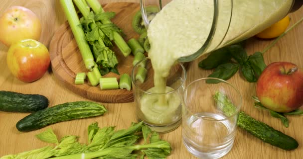 Verter verduras verdes recién exprimidas orgánicas y batido de frutas en el vaso — Vídeo de stock