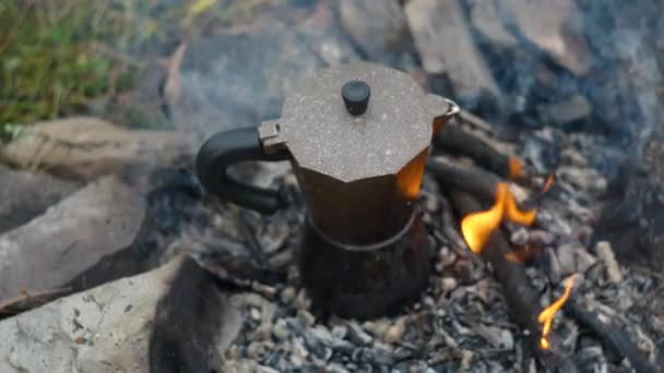 Koffie wordt bereid in een geiser koffiezetapparaat op een kampvuur — Stockvideo