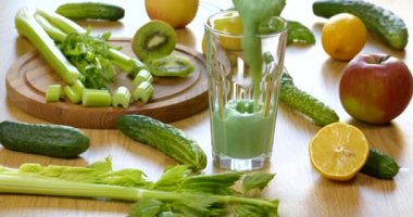 Taze sıkılmış organik sebze ve meyve püresi bardağa dökülüyor.