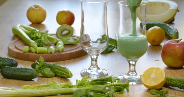 Χύνοντας Βιολογικά Φρεσκοζαρισμένα πράσινα λαχανικά και φρούτα smoothie στο ποτήρι — Αρχείο Βίντεο