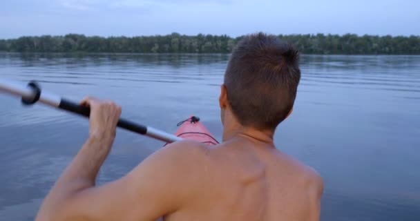 Un hombre kayaks en un río tranquilo — Vídeo de stock