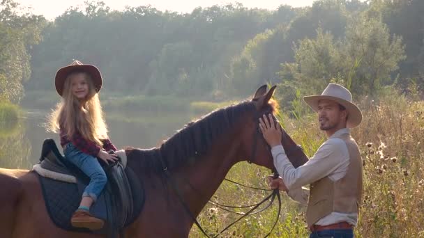 Cowboy and his daughter on horseback — Stock Video