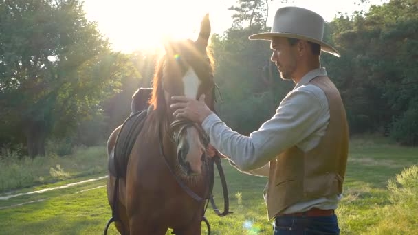 Close-up van de Amerikaanse cowboy strelen paard in slow motion — Stockvideo