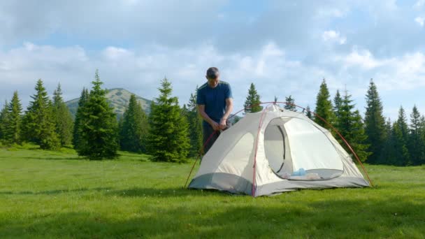 Turista maschio mette una tenda in montagna — Video Stock