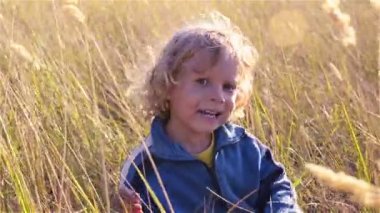 Otların arasında bir çocuk oturur