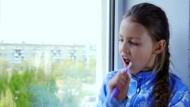 Дівчина чистить зуби зубною щіткою — стокове відео