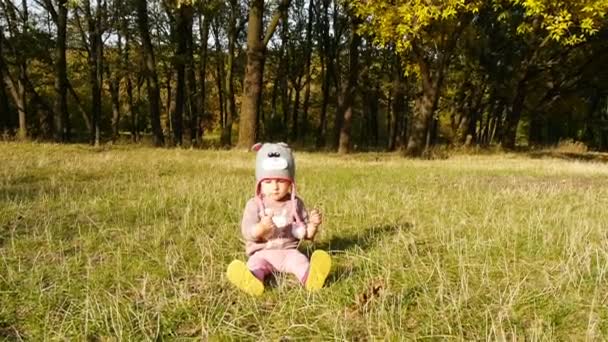 Gelukkig baby zittend op het gras in het park — Stockvideo