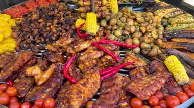 Assorted grilled meat and vegetables on barbecue grill, Colorful mix of grilled ribs, chicken, corn, mushrooms, potatoes and chili peppers on hot BBQ