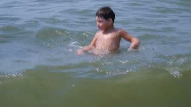 Un niño divirtiéndose en el mar en las olas — Vídeos de Stock