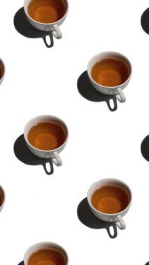 Beyaz arka planda bir sürü çay fincanı olan kusursuz desenler. Sıcak içeceği olan çay fincanları farklı yönlere, dikey görüntülere yönelir.