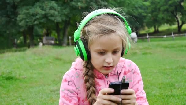 Chica escuchando música desde un teléfono inteligente — Vídeo de stock