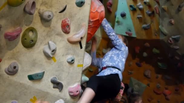 Niña escalando roca en la pared práctica — Vídeos de Stock