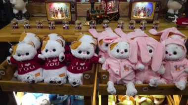 Pofuduk oyuncaklar ve aydınlatılmış dekorasyonlarla süslü dükkan vitrinleri, parıldayan minyatürler, hediyeler, figürler ve rahat kış atmosferinin yer aldığı mevsimlik perakende sergisi