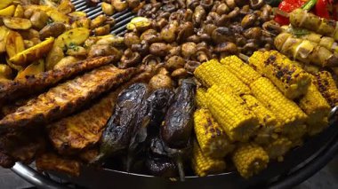 Çeşitli ızgara etler ve sebzeler, kızarmış pirzola, et sosisi, mısır, mantar, patates ve acı biber karışımı sıcak bir barbekü.