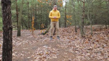 Ortaçağ Ormanının Dışına Atlayan Ortaçağ Ağaç Antrenmanı, ağaçlar arasında kuru yapraklar arasında olgun bireylerin atlama egzersizi