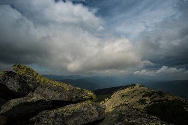 Dağların ve kayaların üzerinde güzel bulutlar. Dağın tepesinden bak