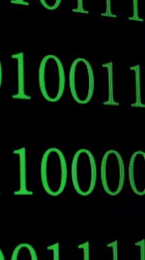 Siyah dijital ekranda, programlamayı, veri şifrelemeyi ve siber güvenliği, dikey görüntüleri sembolize eden yeşil ikili kod birlerinin ve sıfırların büyütülmüş bir resmi.