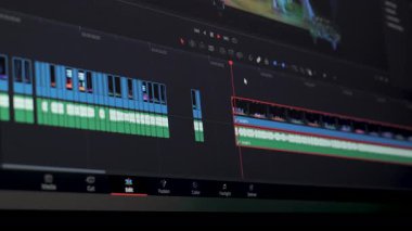 Profesyonel Video Düzenleme Zaman Çizelgesi Bilgisayar Monitöründe, katmanlı görüntü kliplerini, ses parçalarını, işaretleyicileri, denetimleri gösteren dijital iş akışı arayüzü
