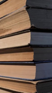 Moving upwards along a stack of books, the concept of education, vertical footage