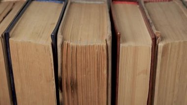 Dikey Yığın Oluşturulmasında Sıralanmış Eski Hardcover Kitaplarının Yakından Görünümü, Kağıt kenarları aşınma işaretlerini gösterir, yaşını, kullanımını, depolama durumunu, yayınlama kalitesini, kütüphane bağlamını gösterir