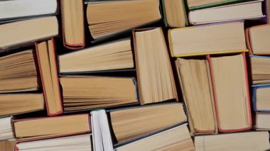 Sayfa kenarları ve bağlayıcıları gösteren üst üste dizilmiş ciltli kitaplar, çoklu eski ciltlerin üst aşağı kompozisyonu dokulu arkaplan olarak sıkıca düzenlenmiştir