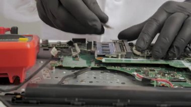 Donanım onarımı sırasında bilgisayarın ana kartına hafıza modülü yerleştiren teknisyen RAM ve devre kartı bileşenleriyle çalışan eldivenli elleri kapatın.