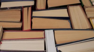 Yukarıdan görülebilen kağıt kenarları olan birikmiş ciltli kitaplar, soyut eğitim geçmişini yakından oluşturan basılı ciltler