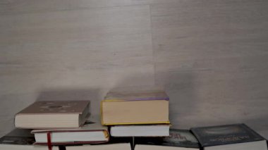 Eğitimsel bir kavram için dokulu bir arka plana karşı dizilmiş eski kitapların Duruşu, bilgi ve öğrenmeyi sembolize eden, birbirine yakın bir ciltli kitap koleksiyonu.