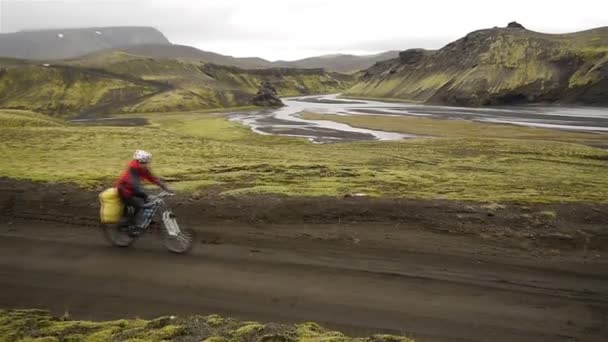 Cyklisté v údolí horské řeky. Island. — Stock video