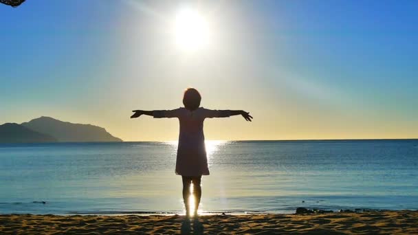 Mar. Nascer do sol. A menina na praia cumprimenta o nascer do sol — Vídeo de Stock