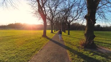 İngiltere 'de, gün batımında parkta yürümek.