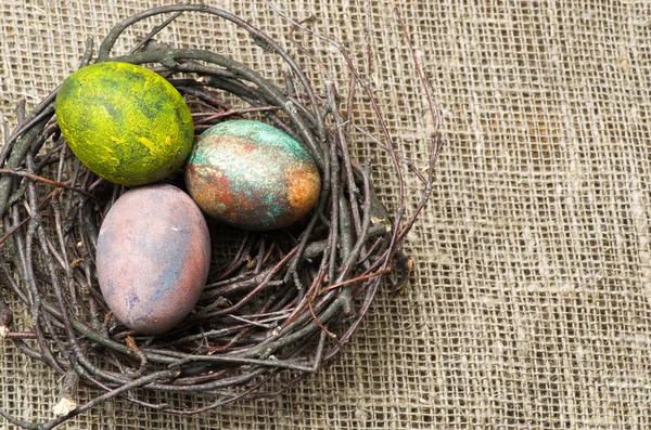 Ovos de Páscoa no ninho em fundo de madeira . — Fotografia de Stock