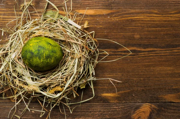 Easter eggs in the nest on wooden background. — Stock Photo, Image