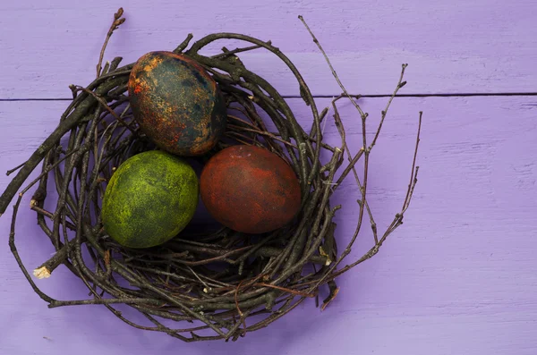 Easter eggs in the nest on wooden background. — Stock Photo, Image