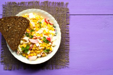 Yengeç ahşap bir masa üzerinde bir tabak salata. Rustik tarzı