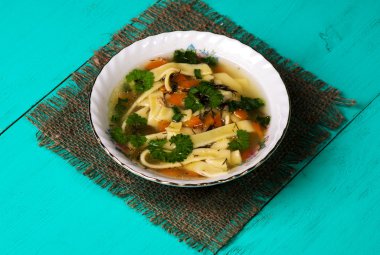 tahta masa üzerinde tabakta şehriye çorbası .