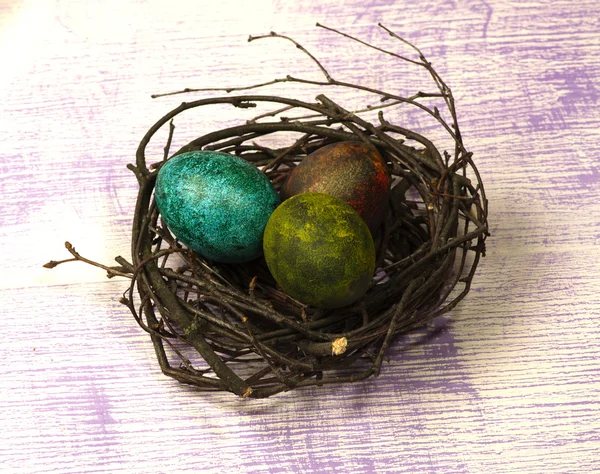 Ovos de Páscoa no ninho em fundo de madeira . — Fotografia de Stock