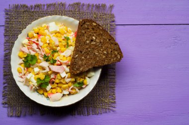 Yengeç ahşap bir masa üzerinde bir tabak salata. Rustik tarzı