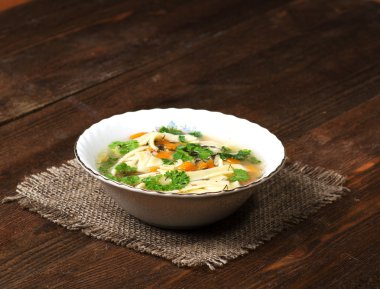 tahta masa üzerinde tabakta şehriye çorbası .